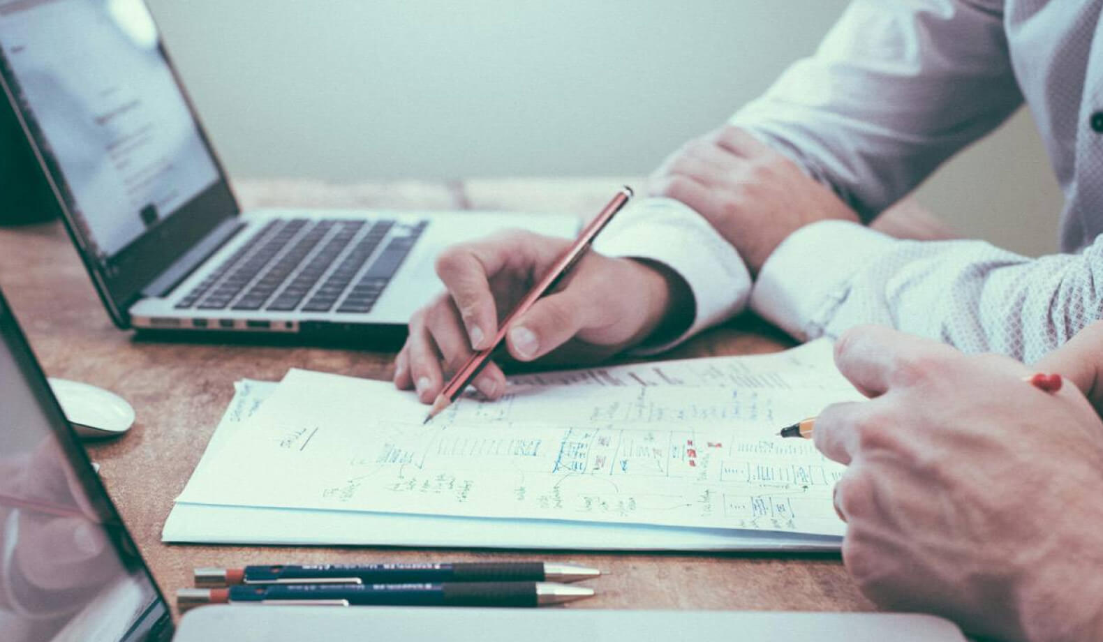 litigation-support@2x Two people at a desk looking through financial paperwork. Photo by Scott Graham on Unsplash.